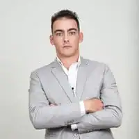 Man in gray suit with crossed arms, professional appearance, business attire, confident businessman, corporate fashion.